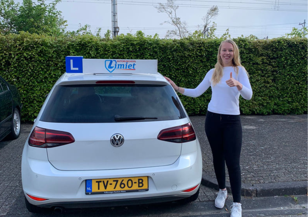 Geslaagde leerling bij de lesauto